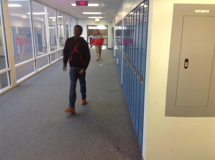Students walk past a bank of lockers during a class period.